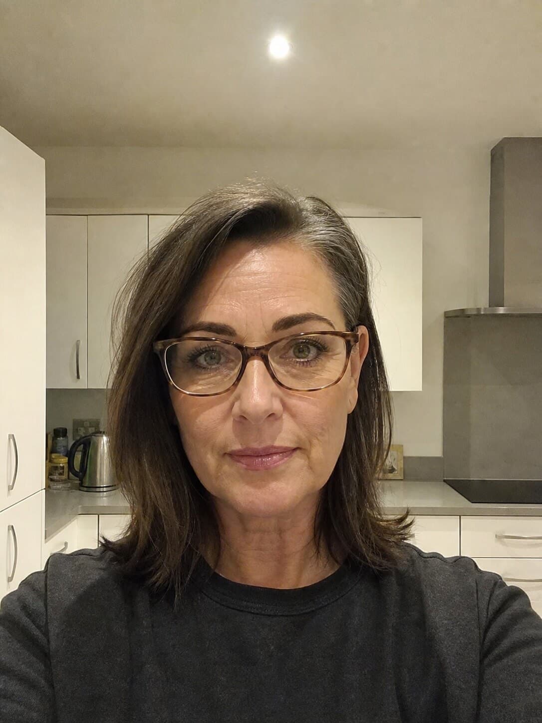 A kitchen selfie under an overhead light and the document photo made from it