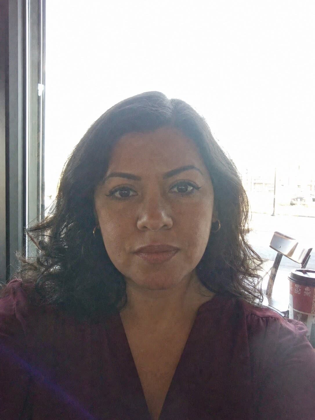 A backlit selfie against a café window and the document photo made from it